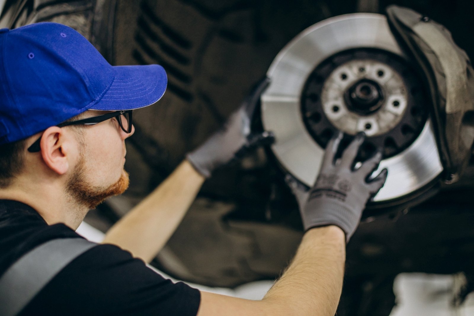 Mechanic changing brake discs in car service